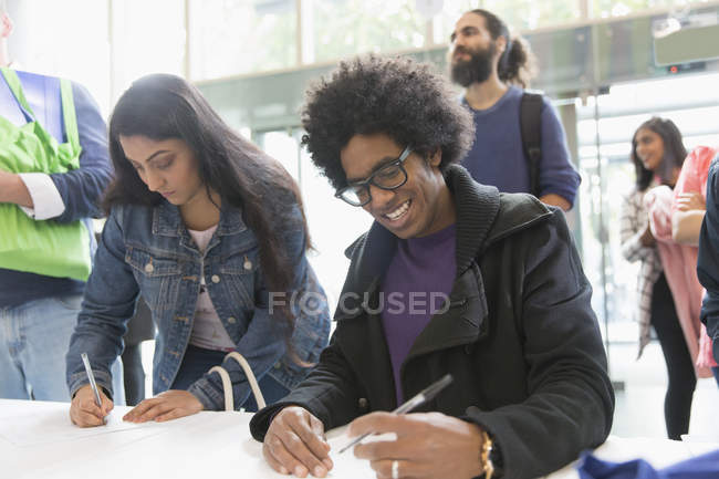 Business people arriving, checking in for conference at registration table — Stock Photo