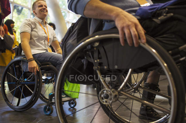 Люди, прибывающие в инвалидных колясках в современный офис — стоковое фото