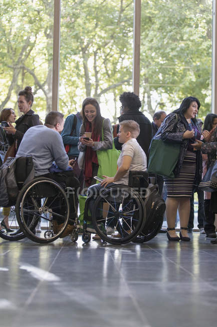 Ділових людей в інвалідних візках, говорити в фойє на конференції — стокове фото