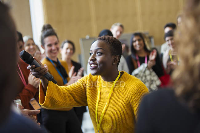 Female speaker with microphone answering audience questions — Stock Photo