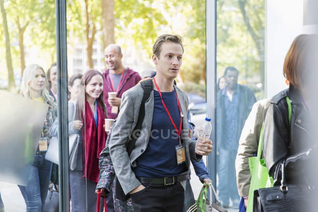 Business people arriving at conference, entering doorway — Stock Photo