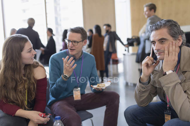 Business people talking and using smart phone at conference — Stock Photo