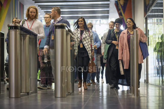 Business people arriving, nearing turnstiles at modern office — Stock Photo