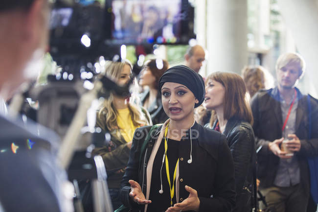 Cameraman riprese donna d'affari parlando in conferenza — Foto stock