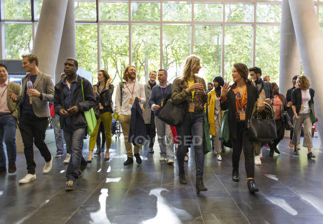 Ділові люди, які прибувають на конференцію, гуляють у вестибюлі — стокове фото