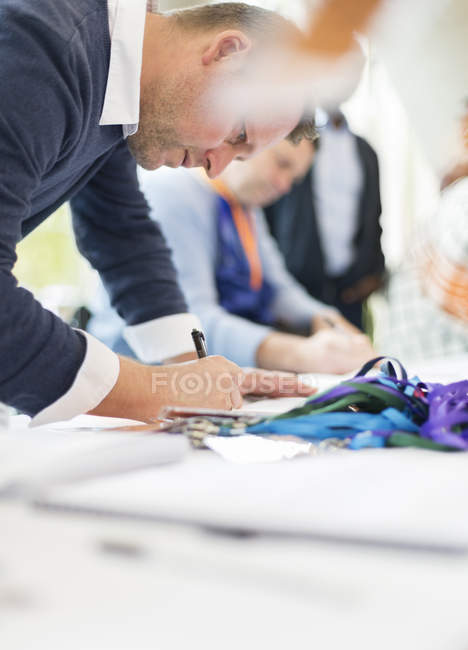 Empresário que faz o check-in na mesa de inscrição da conferência — Fotografia de Stock