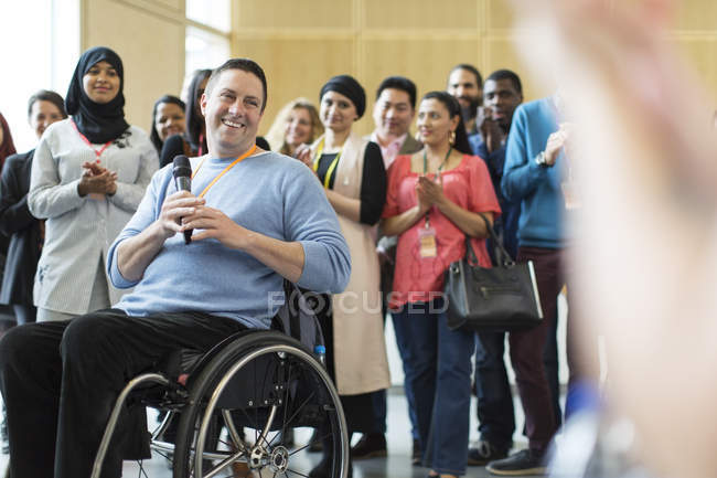 Audiência aplaudindo para orador masculino em cadeira de rodas — Fotografia de Stock