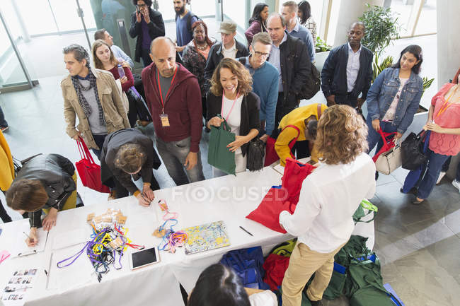 Personas de negocios registrándose en la mesa de inscripción de la conferencia - foto de stock