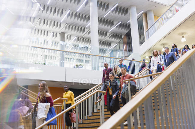 Деловые люди спускаются по современной офисной лестнице — стоковое фото