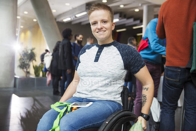 Портрет усміхненої молодої жінки в інвалідному візку на конференції — стокове фото