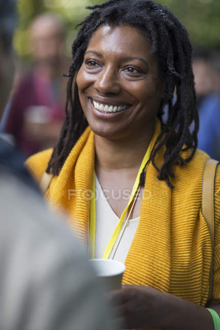 Una donna d'affari sorridente che parla con un collega alla conferenza — Foto stock