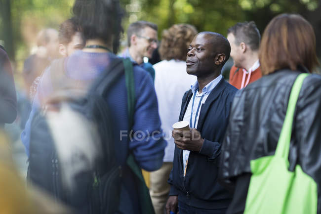 Uomo d'affari con caffè parlare con i colleghi in conferenza — Foto stock