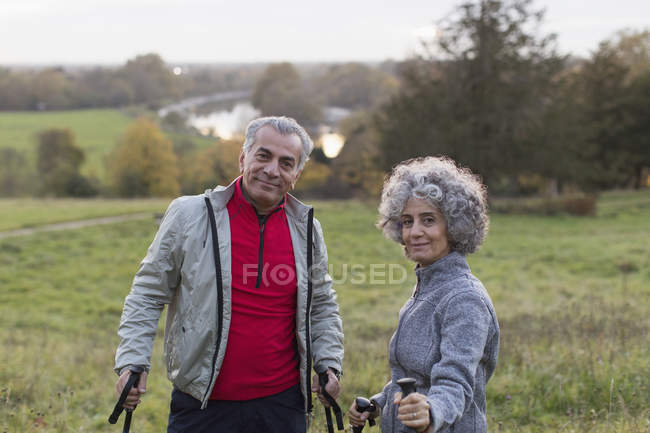 Portrait confident active senior couple hiking in rural field — Stock Photo
