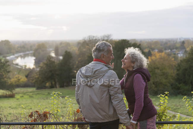 Улыбающаяся, любящая активная пожилая пара в осеннем парке — стоковое фото
