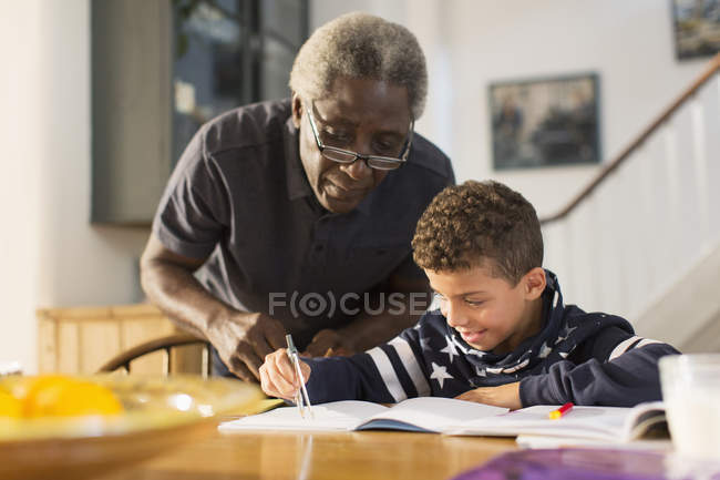 Großvater hilft Enkel bei Hausaufgaben — Stockfoto