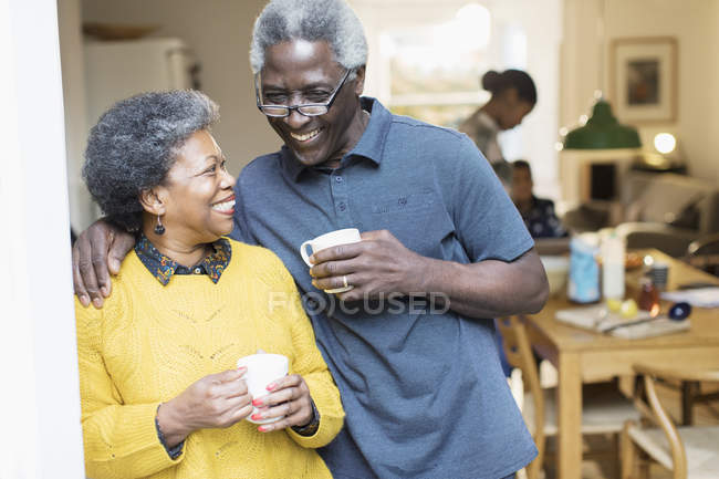 Happy, affectionate senior couple drinking coffee — Stock Photo