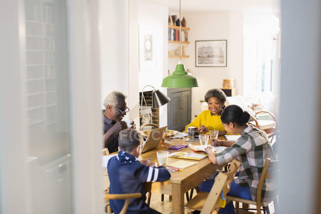 Nonni a tavola con nipotini che fanno i compiti — Foto stock