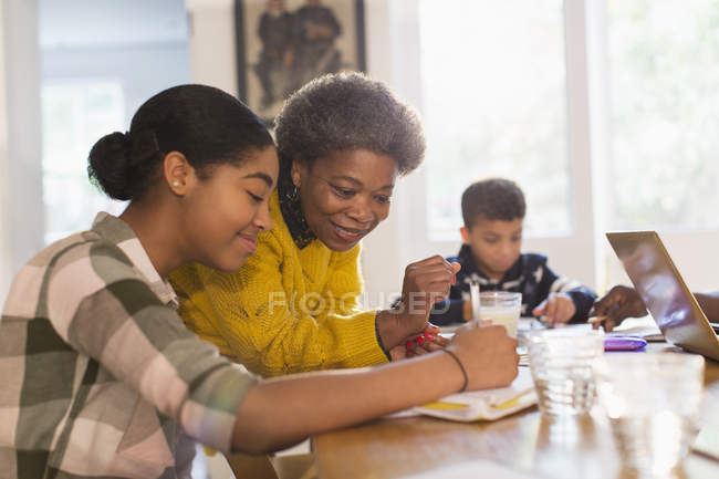 Бабуся допомагає онуці з домашнім завданням — стокове фото
