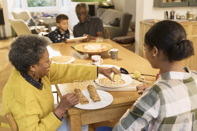 Nonna e nipote mangiare crepes a tavola — Foto stock