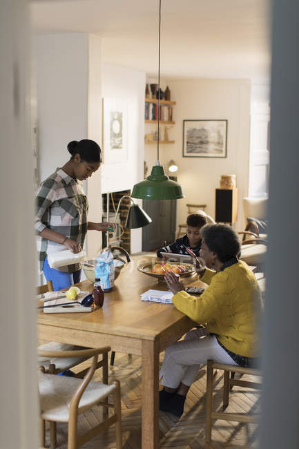 Бабушка и внуки пекут за обеденным столом — стоковое фото