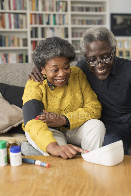 Coppia anziana che controlla la pressione sanguigna a casa — Foto stock
