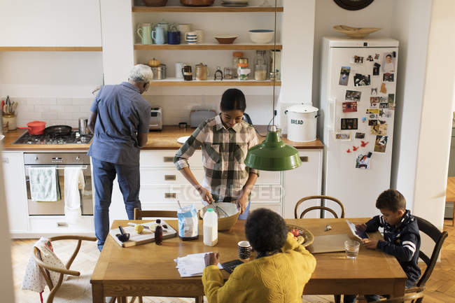 Бабусі і дідусі випікають і використовують цифровий планшет на кухні — стокове фото