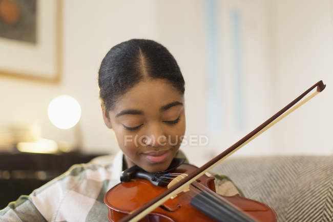 Сосредоточенная девочка-подросток играет на скрипке — стоковое фото