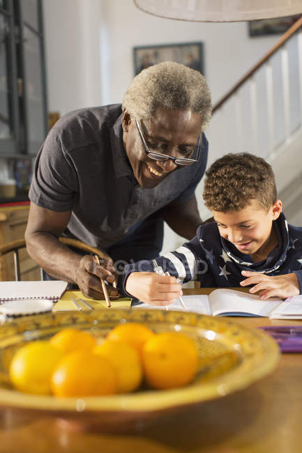 Grandfather helping grandson with geometry homework — Stock Photo