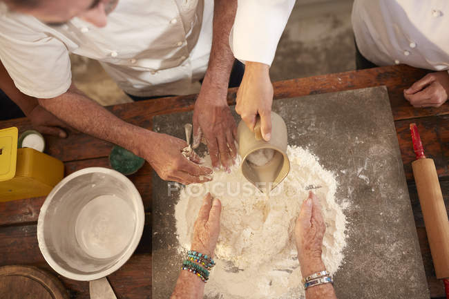 Overhead view chefs making pizza dough flour nest — Stock Photo