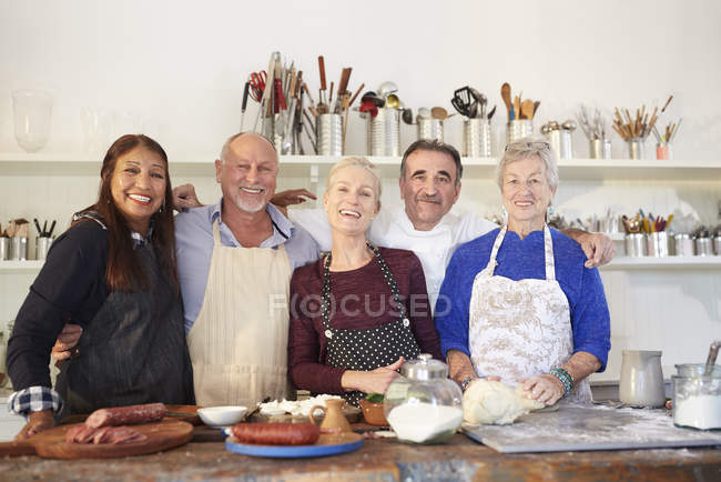 Retrato feliz, seguro de amigos mayores y chef en la clase de cocina de pizza - foto de stock