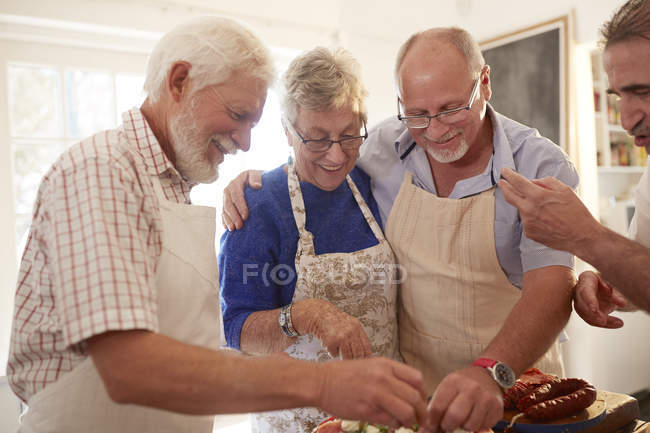 Amigos mayores disfrutando de clases de cocina - foto de stock