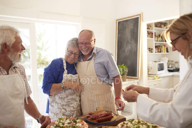 Affectueux couple de personnes âgées profitant de cours de cuisine à pizza — Photo de stock