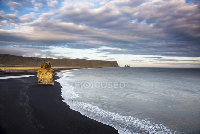 Schwarzer Sandstrand und ruhiger, abgelegener Ozean, dyrholaey, Island — Stockfoto