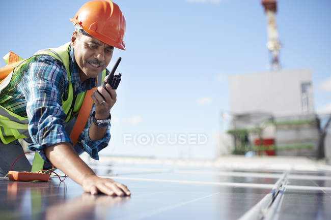 Ingénieur avec talkie-walkie inspectant le panneau solaire à la centrale électrique — Photo de stock