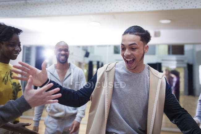 Enthusiastic teenage boy high-fiving classmate in dance class studio — Stock Photo