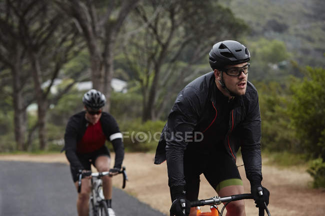 Cycliste masculin déterminé sur la route — Photo de stock