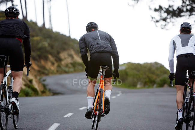 Male cyclists cycling at mountain road — Stock Photo