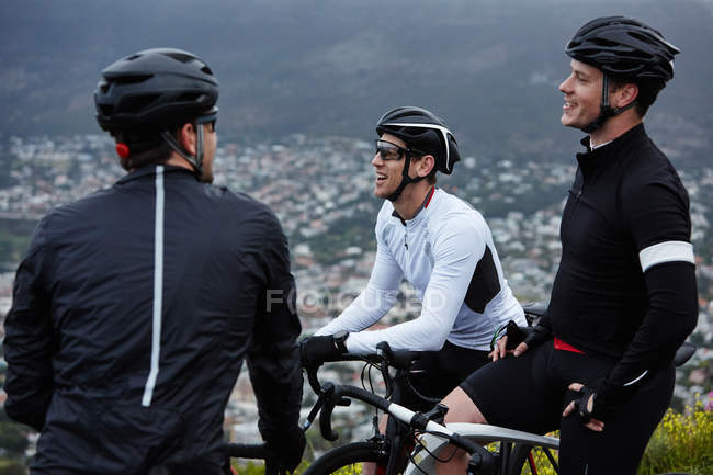 Male cyclist friends taking a break, talking — Stock Photo