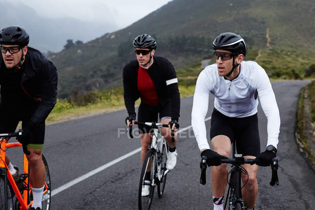 Ciclistas masculinos ciclismo en carretera de montaña - foto de stock