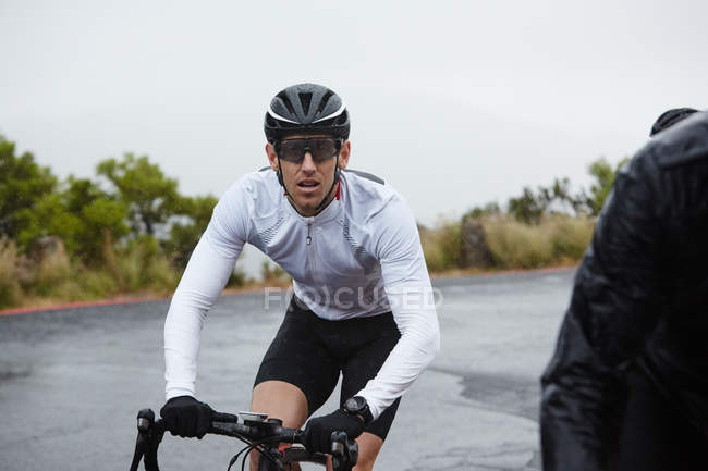 Dedicated male cyclist cycling at mountain road — Stock Photo
