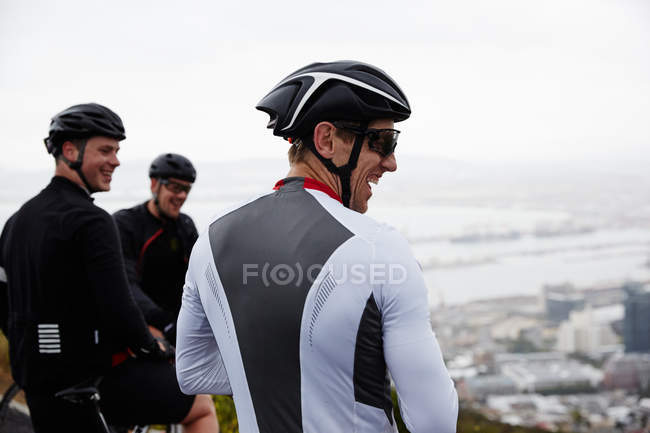 Smiling male cyclist friends taking a break — Stock Photo