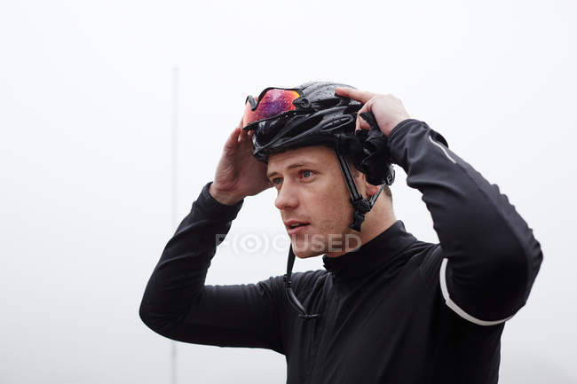 Ciclista focalizzato maschile con casco e occhiali — Foto stock