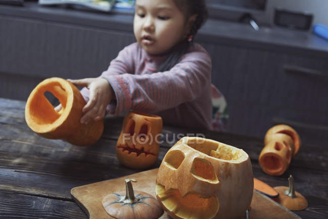 Девушка, вырезающая тыквы на Хэллоуин — стоковое фото