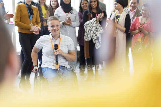 Audiência aplaudindo para orador feminino em cadeira de rodas — Fotografia de Stock