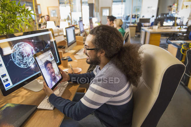 Criativa designer de vídeo conversando com colega em tablet digital no escritório — Fotografia de Stock