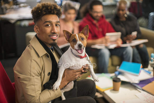 Retrato sorridente criativo empresário com cão no escritório — Fotografia de Stock