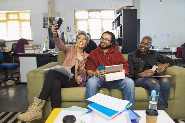 Gente de negocios creativa feliz tomando selfie en oficina abierta casual - foto de stock