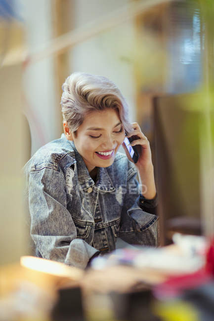 Lächelnde junge Frau im Gespräch mit dem Smartphone — Stockfoto