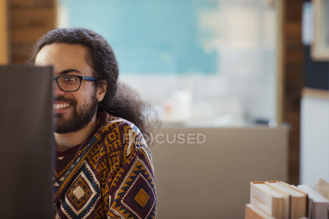 Sonriente empresario creativo trabajando en la computadora - foto de stock