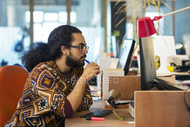 Homme d'affaires créatif concentré travaillant à l'ordinateur dans le bureau — Photo de stock